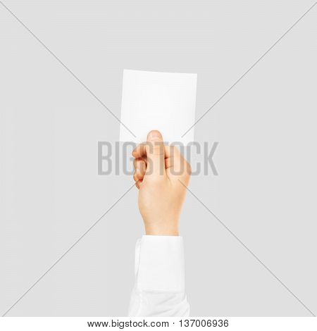 Hand holding square blank white sticker mock up isolated on gray. Sticker mockup holder. Empty paper clue remnder hold in hands.