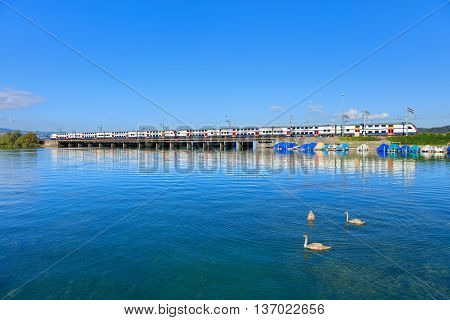 Rapperswil, Switzerland - 7 September, 2015: a train passing the Seedamm. Seedamm is the partially artificial causeway and bridge at the most narrow area of Lake Zurich between the town of Hurden and the city of Rapperswil.