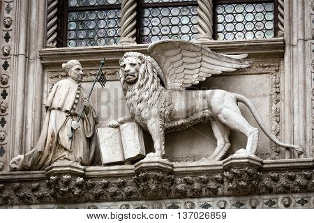 Statue of the Doge Francesco Foscari (1423-1457) kneeling before the Lion of St. Mark on the Doge Palace facade in Venice Italy