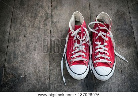 Red sneakers on wooden floor vintage style