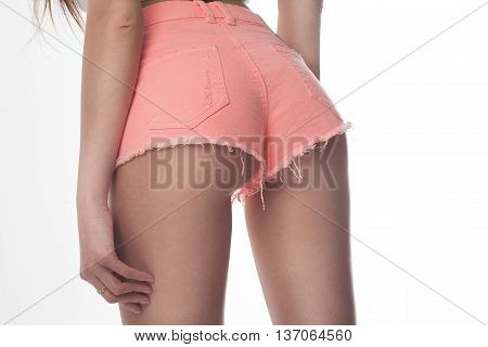 Sexy woman body in jeans shorts. The model is back. Great ass. Studio shot on white background.