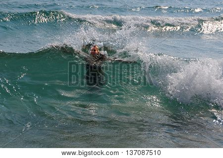 PRIMORSKO BULGARIA - JUNE 30 2016: Young girl in the waves of the Black sea in the summertime