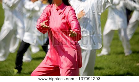 Woman With Pink Silk Dress Perform The Exercises In The Park