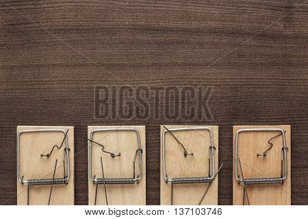 some mousetraps on the brown wooden background
