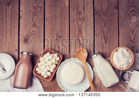 Milk and cheese on wooden background. View from above. Flat lay