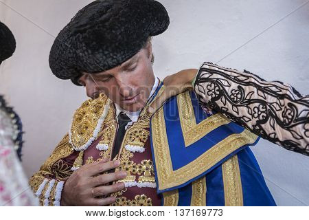 Cabra Spain - September 5 2010: The Spanish Bullfighter Jose Luis Moreno putting itself the walk cape in the alley before going out to bullfight typical and very ancient tradition in Cabra Spain