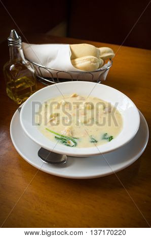 Creamy chicken gnocchi traditional Italian soup with bread and oilve oil