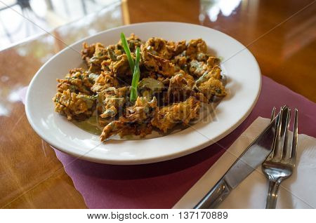 Deep fried breaded Indian onion pakora with green bell pepper garnish