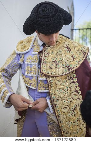 Baeza SPAIN - August 15 2014: Spainish bullfighter Sebastian Castella putting itself the walk cape in the alley before going out to bullfight typical and very ancient tradition in Baeza Jaen province Spain