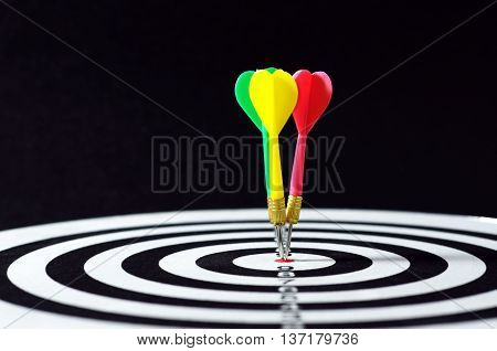 Three Darts On Target. Horizontal Shot With Black Background.