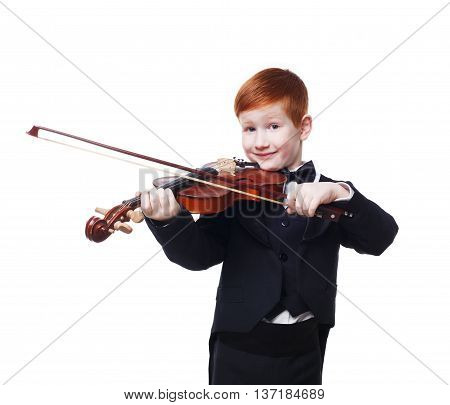 Cute redhead child plays violin isolated at white background. Red-haired charming boy musician in tailcoat or tuxedo. Classical music study concept