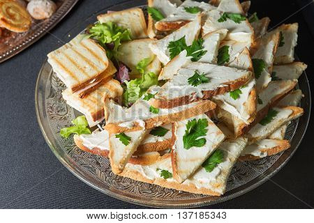 Cheese sandwiches and egg salad, arranged on a platter and garnished with parsley.