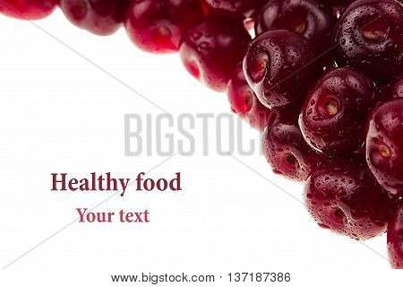 Heap of ripe cherries with water drops on a white background. Decorative frame of fruits. Isolated. Macro. Food background. Copy space.