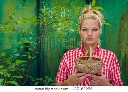Blonde girl on a green background holding a basket. Rockabilly style. Space for text