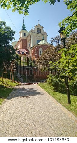 WARSAW - POLAND. A look at St. Anne's Church on a clear blue sky surrounded by trees.