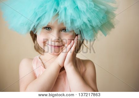 Little girl looking at camera putting her hands under her cheek