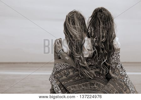 Two beautiful boho girls watching the hotizon