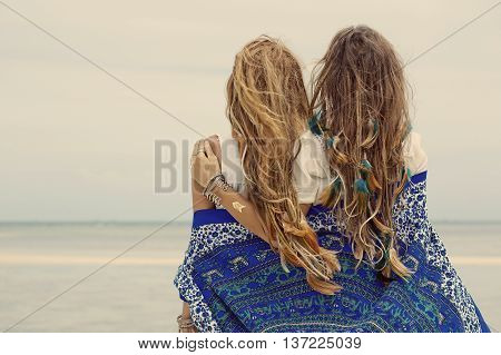 Two beautiful boho girls watching the hotizon