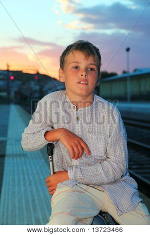 kleiner Junge sitzt auf big-Bag auf Plattform-Bahn am Abend