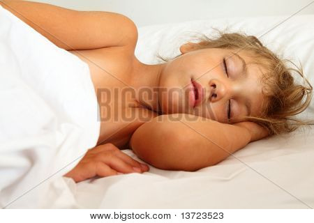 linda menina dormindo na cama no lençol branco e travesseiro