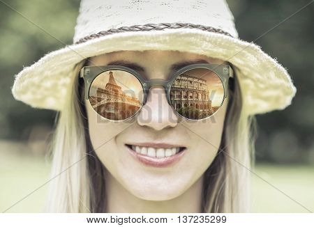 Woman in sunglasses and hat with traval images.