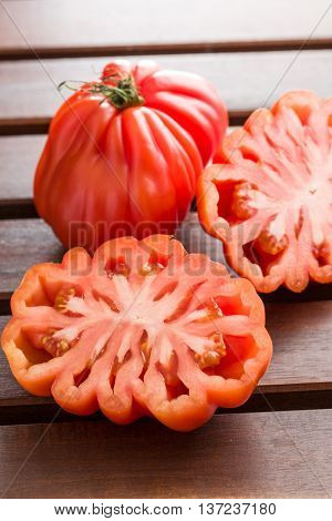 Coeur De Boeuf. Beefsteak tomatoes on wooden table.