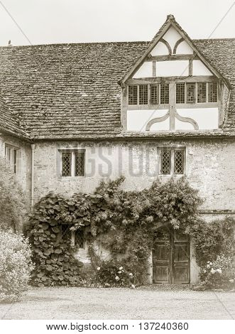 LACOCK ABBEY, LACOCK, WILTSHIRE, UK, 21 JUNE 2016 - Corner of the Tudor courtyard in Lacock Abbey Wiltshire UK in sepia tone
