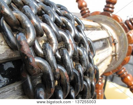 old historical helm with rusty chain control