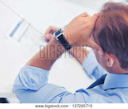 business, office, school and education concept - stressed man filling tax form
