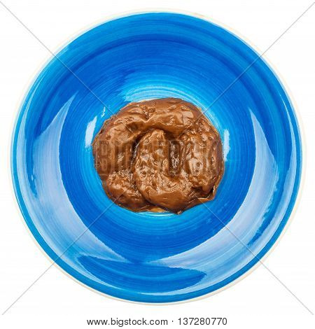 Fake rubber excrement in a blue plate isolated on white background