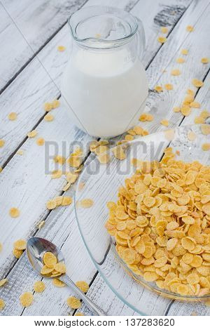 Cornflakes and milk on white wooden background. Morning breakfast. Rustic style.