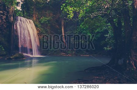 Tropical rainforest waterfall in Kanchaburi Thailand. Vintage filtered effect image