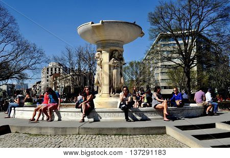 Washington DC - April 12. 2014: People relaxing in front of Daniel Chester French's marble fountain in the center of Dupont Circle on a warm Spring afternoon