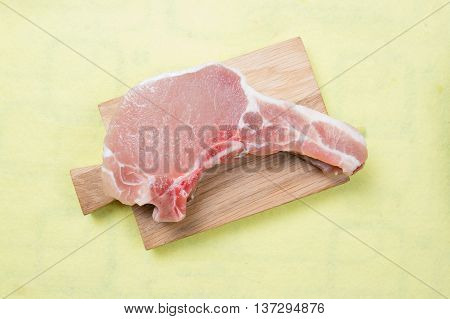 Raw porkchop on wooden broad / cooking porkchop steak concept
