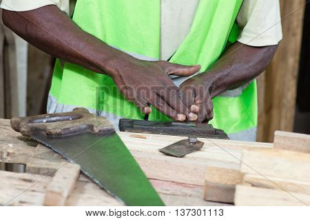 The carpenter whet his plane and saw in front of him.