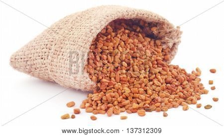 Fenugreek seeds in sack over white background