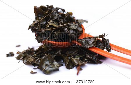 Fried moringa leaves in a spoon over white background