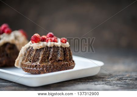Mini chocolate bundt cake with cheese cream and strawberries on a white tray