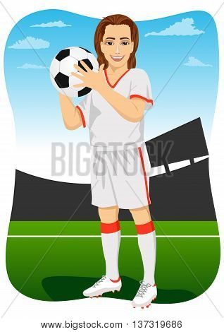 Young soccer player holding a ball and posing in the stadium