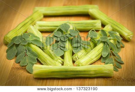 Medicinal moringa oleifera with leaves on wooden surface