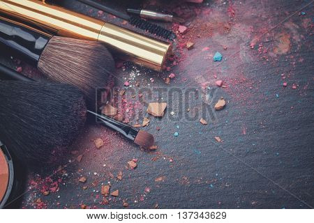 set of brushes and maskara on black background, retro toned