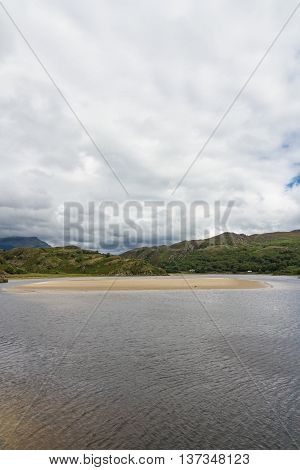 View of the River Dwyryd near Penrhyndeudraeth. Sand bank trees and rocky hills. Gwynedd Snowdonia Wales United Kingdom.