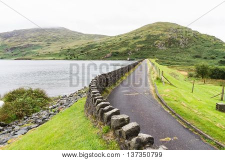 Dull day dam of Llyn Cwmystradllyn reservoir near Portmadog Gwynedd Wales UK.
