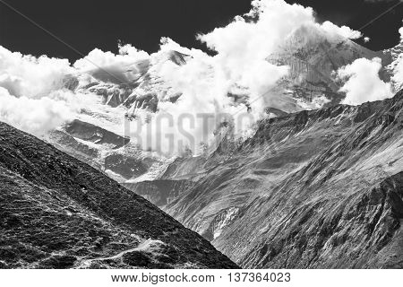 Snow covered mountain top engulfed in clouds. Annapurna region in Himalaya.
