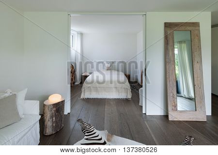 living room with bedroom view, white walls