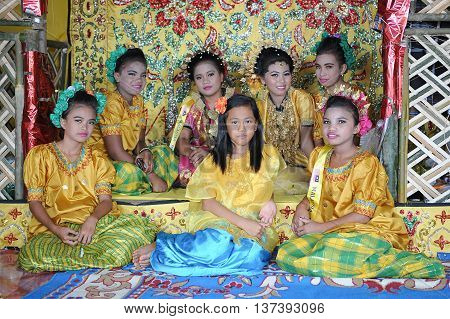 Sipitang Sabah Malaysia.August 30 2014 : A group of young girls from the Bugis ethnicity sitting on a decorated dais during Gata Festival in Sipitang Sabah Malaysia.