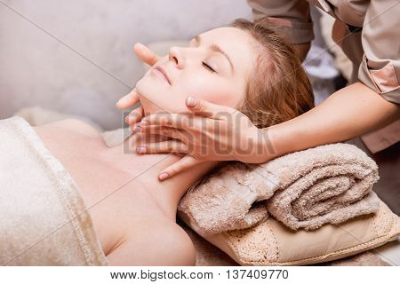 Caucasian woman having anti-aging Face massage. Spa Salon rejuvenating Face massage closeup
