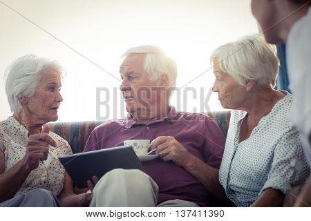 Seniors using a tablet computer in the retirement house