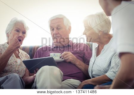 Seniors using a tablet computer in the retirement house
