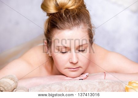 healthy and beautiful blond woman in spa salon. Traditional oriental aroma therapy and beauty treatments.